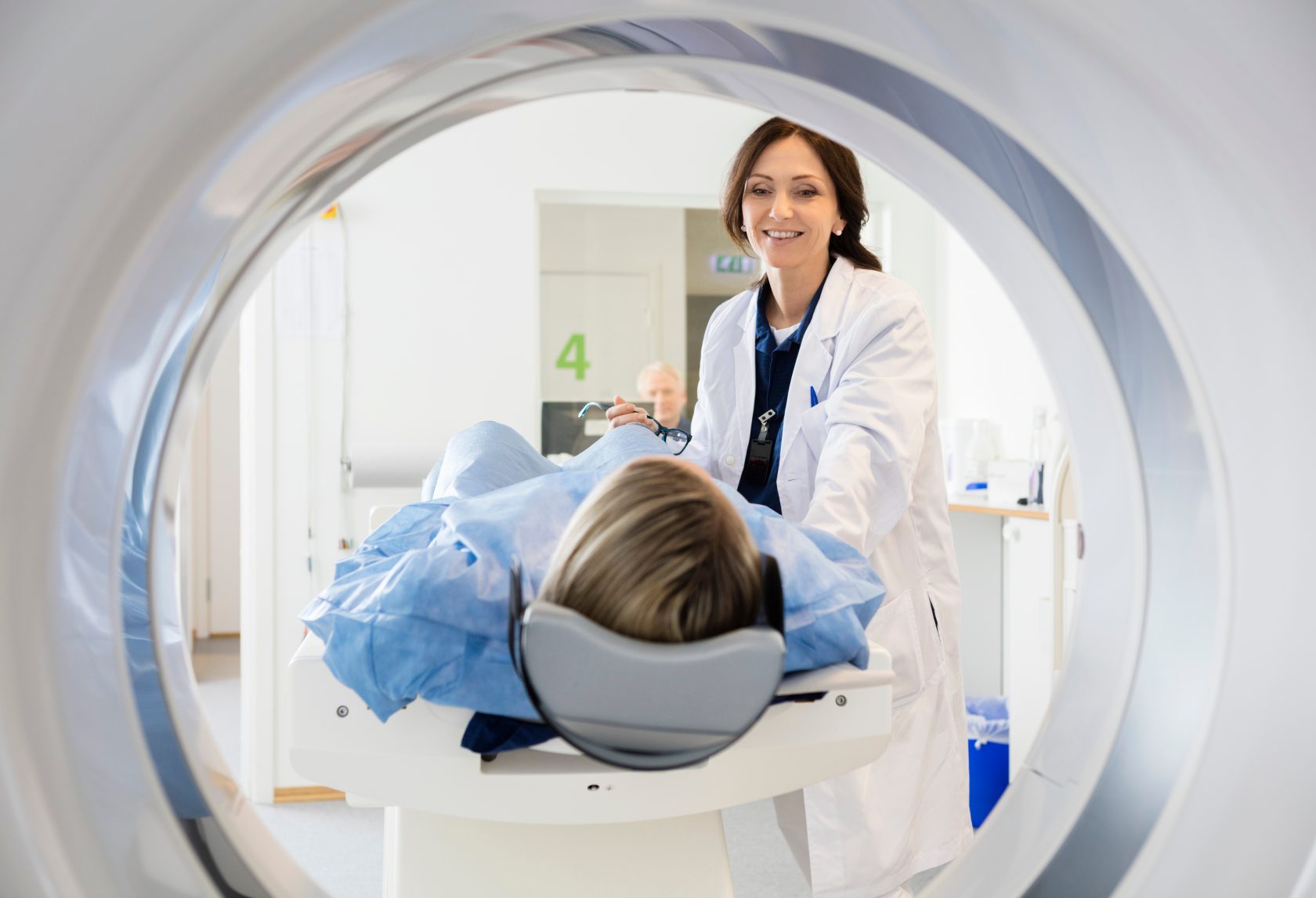 Female Doctor Looking At Patient Undergoing CT Scan