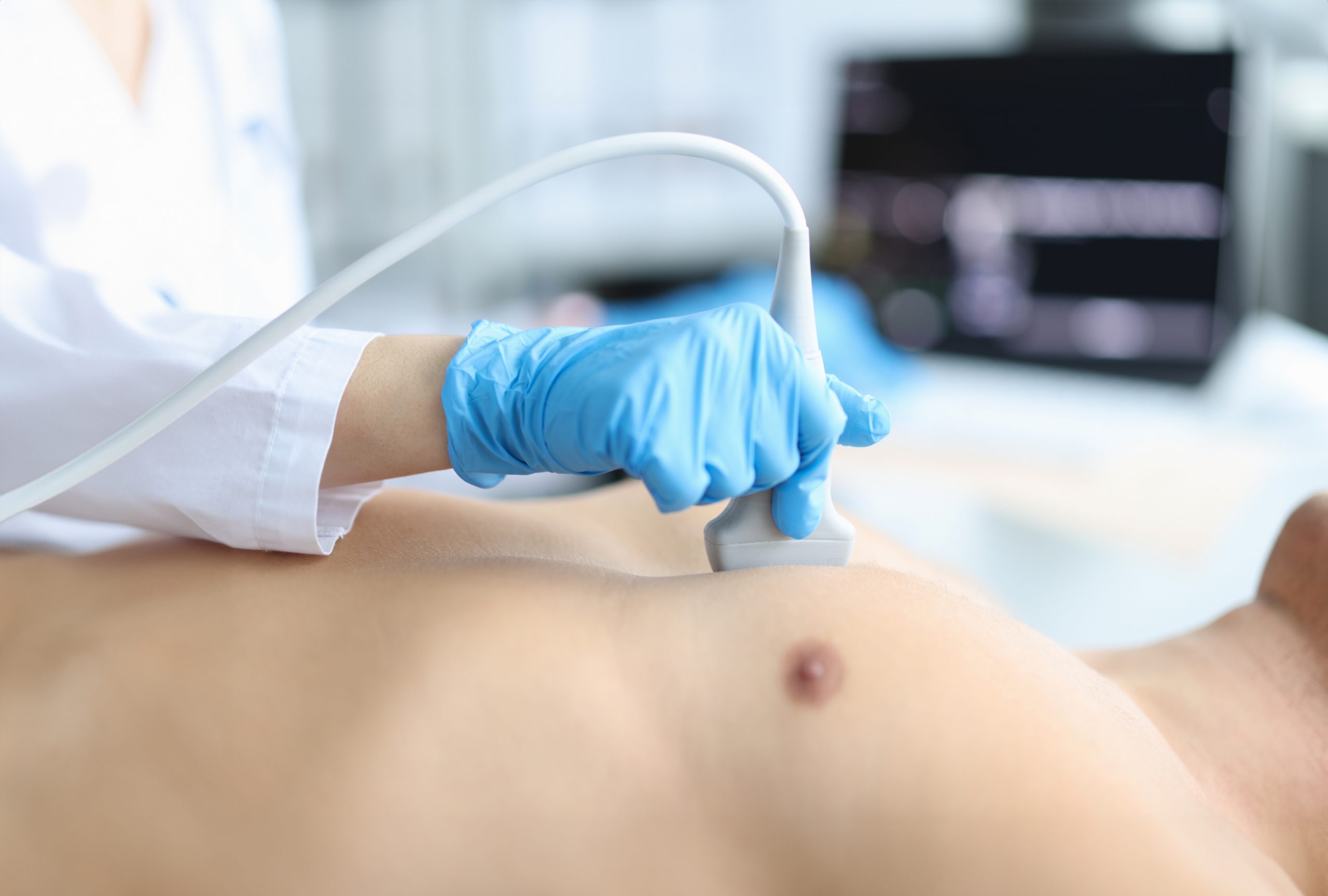 Doctor makes echocardiography of male patient using ultrasound probe pressing on patient chest