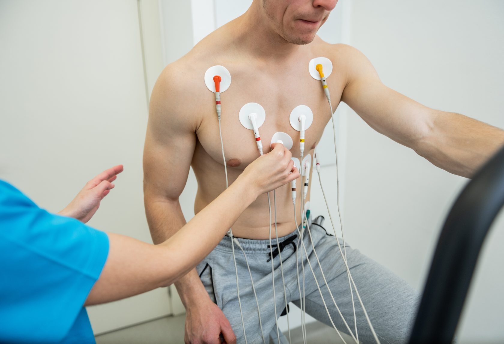 A patient undergoing a cardiac test with electrodes attached to their chest.