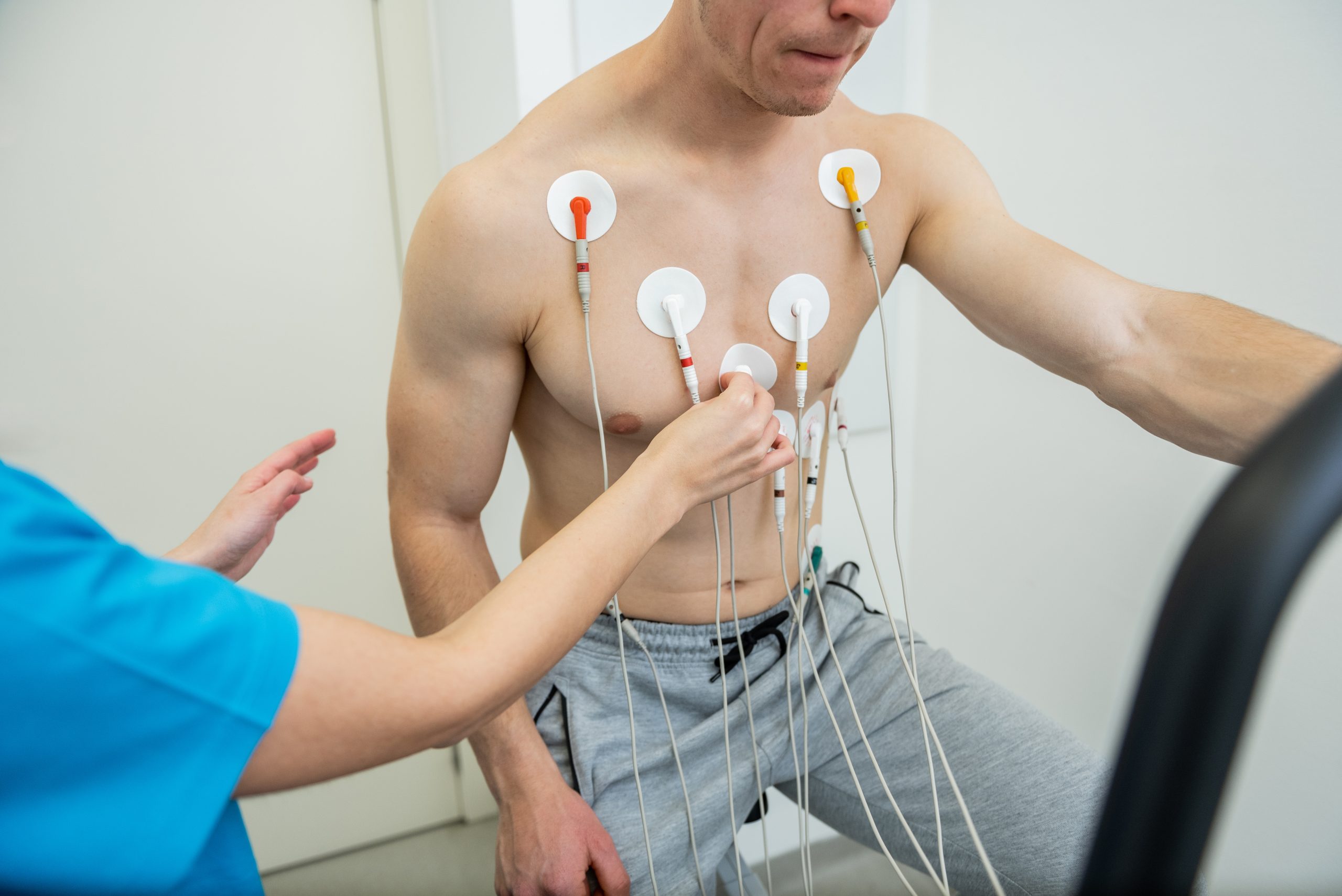 A patient undergoing a cardiac test with electrodes attached to their chest.
